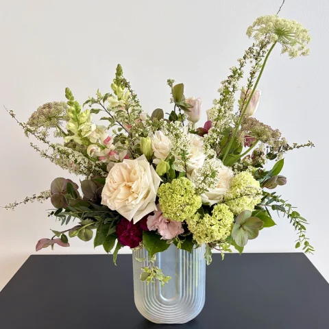 Mixed floral arrangement in ribbed glass vase