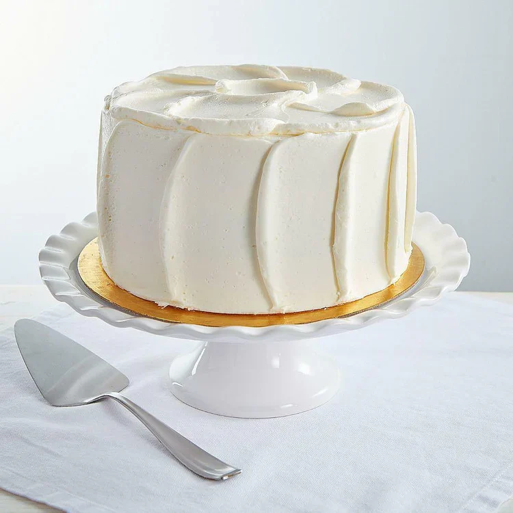 White frosted layer cake on pedestal stand