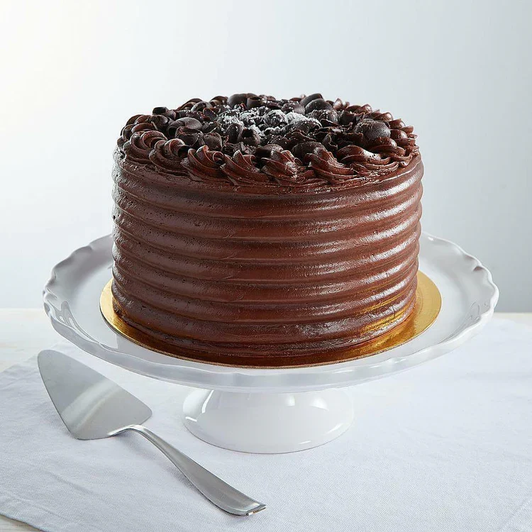 Chocolate layer cake on white cake stand