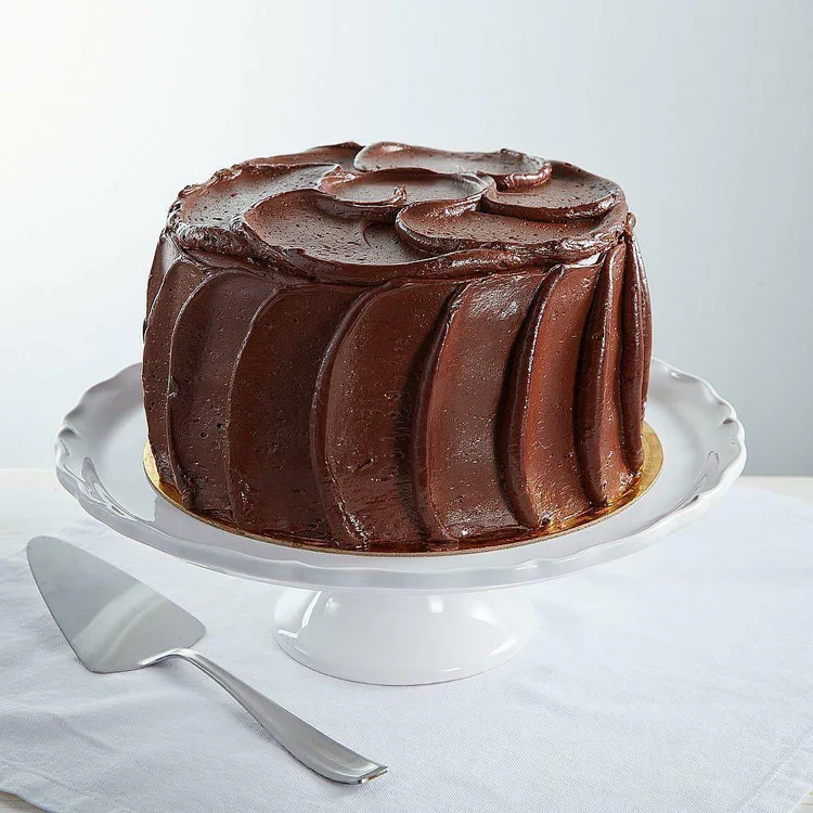 Chocolate frosted layered cake on white stand