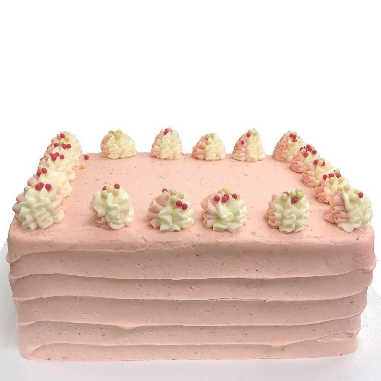 Rectangular pink frosted cake with piped rosettes